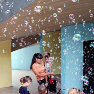 Liquide pour machine à bulles qui crée des bulles avec une femme et des enfants qui s’amusent avec des bulles