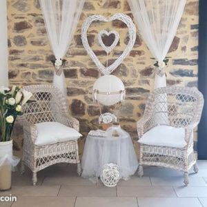 Fauteuils et coeurs en osier blanc avec rideaux et décorations de mariage bucoliques